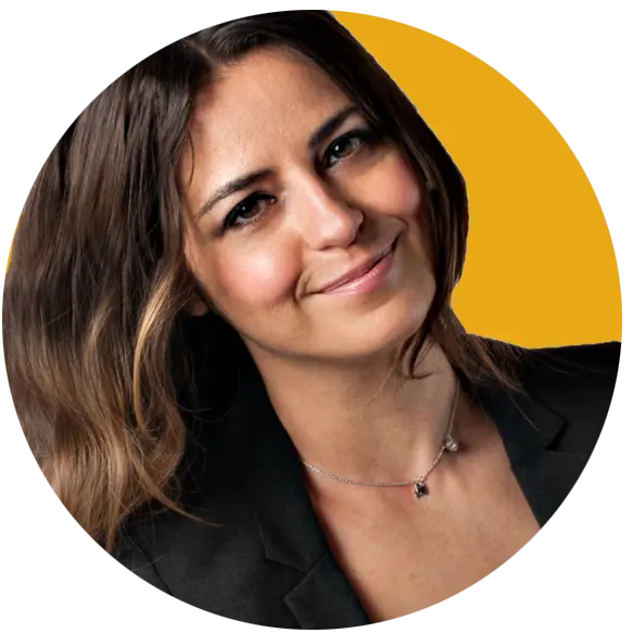 Image of Kinga Mroz web developer at Sprout Your Practice smiling at the camera wearing a black blazer on a yellow background